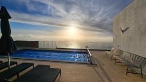 una piscina en el balcón de un edificio en Majestic Seaview Villa, en Fajã da Ovelha