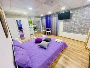 1 dormitorio con cama morada y almohadas en Studio 21, en Varna