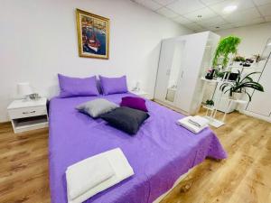 Cama morada con 2 almohadas en una habitación en Studio 21, en Varna
