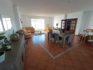 a kitchen and living room with a table and chairs at Casa La Romana in Aracena