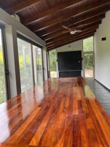 Cette chambre comprend une grande table en bois et des fenêtres. dans l'établissement Quinta con piscina Laguna Sur Bitcoins House, à Corrientes