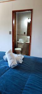 um quarto com uma cama azul com toalhas em La Casona Caburgua em Pucón