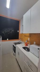 a kitchen with a sink and a black chalkboard on the wall at Apê in Copacabana in Rio de Janeiro