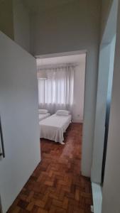 a bedroom with a white bed and a window at Apê in Copacabana in Rio de Janeiro
