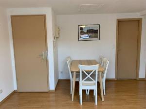 a dining room with a table and chairs and a door at Cozy Little One Room Appartment, a tranquil haven! in Mulhouse