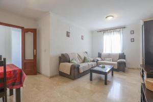 uma sala de estar com um sofá e uma mesa em Santa María 13 em Huelva