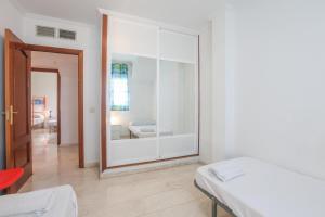 um quarto branco com um espelho e uma cama em Santa María 13 em Huelva