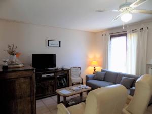 ein Wohnzimmer mit einem Sofa und einem TV in der Unterkunft Royan - MAISON de PLAIN-PIED avec jardin clos - QUARTIER RESIDENTIEL in Royan