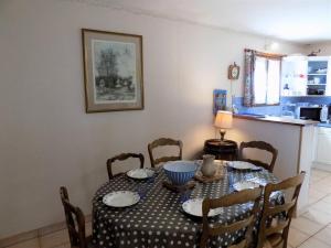 ein Esszimmer mit einem Tisch und Stühlen sowie eine Küche in der Unterkunft Royan - MAISON de PLAIN-PIED avec jardin clos - QUARTIER RESIDENTIEL in Royan