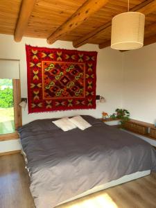 a bedroom with a bed with a red blanket on the wall at Casa con costa del lago in Dina Huapi