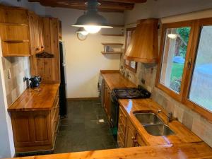 a kitchen with wooden counter tops and a sink at Casa con costa del lago in Dina Huapi