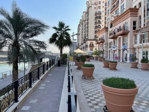 una calle de la ciudad con palmeras y edificios en Great view, Dubai SportCity, parking included, nice Apartments, en Dubái