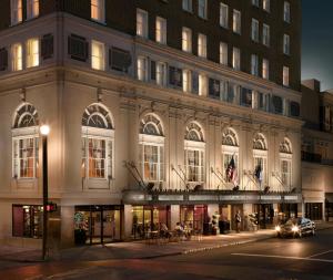 un gran edificio en una calle de la ciudad por la noche en Francis Marion Hotel en Charleston