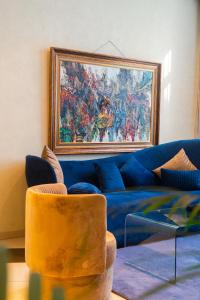 a living room with a blue couch and a painting on the wall at Kenzi Solazur in Tangier