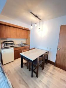 a kitchen with a table and chairs in a room at Bello departamento frente a las montañas in Los Penitentes