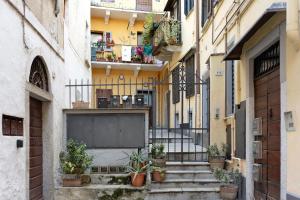 韋爾巴尼亞的住宿－Gigi House，一条有楼梯、盆栽植物和建筑的小巷