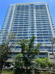 un edificio alto con árboles delante de él en Loop Spacious Studio Unit, en Cagayan de Oro