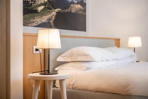 a bedroom with a bed and a table with a lamp at Chalet Falorie in Cortina dʼAmpezzo