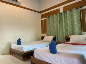 Dos camas en una habitación con bolsas azules. en Phi Phi Twin Palms Bungalow, en Islas Phi Phi