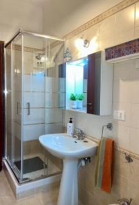 a bathroom with a sink and a glass shower at Ambrazzurra Apartament in Aci Castello