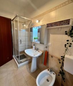 a bathroom with a sink and a toilet and a shower at Ambrazzurra Apartament in Aci Castello
