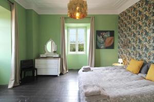 a green bedroom with a bed and a mirror at Casa Mahalia - Calme et Campagne in Carril