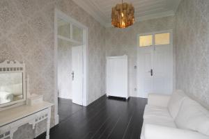 a living room with a white couch and a chandelier at Casa Mahalia - Calme et Campagne in Carril