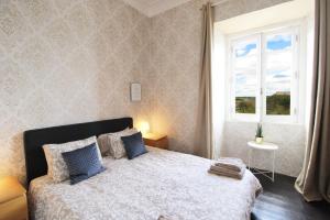 a bedroom with a bed with blue pillows and a window at Casa Mahalia - Calme et Campagne in Carril +12 photos