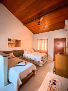a room with two beds and a couch in it at Pousada Caminho do Mar in Cabo Frio