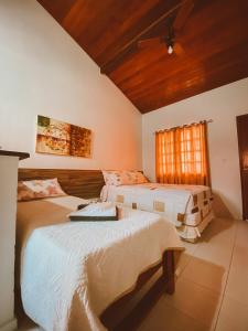 1 dormitorio con 2 camas y techo en Pousada Caminho do Mar, en Cabo Frío