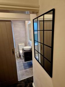 a bathroom with a toilet and a sink and a mirror at Over Torrs Cottage in New Mills +37 photos