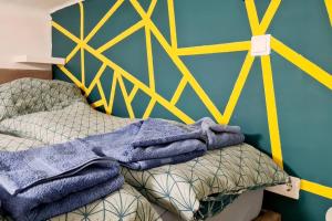 a bedroom with a bed with a yellow and blue wall at La Vida Loca Apartment in Budapest
