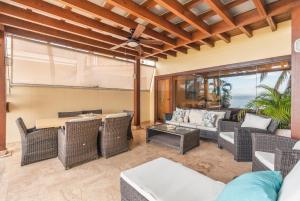 an outdoor living room with wicker furniture and a table at Breakfast Included Marina Town House at Puerto Bahia in Santa Bárbara de Samaná