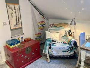 Schlafzimmer mit einem Bett und einer roten Kommode in der Unterkunft Les Trois Blocs in Newcastle