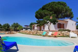 una piscina con sillas y una casa en Villa 2 Pini, en Alcamo