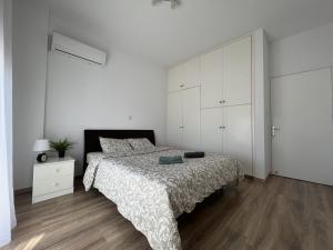 a white bedroom with a bed and white cabinets at Sunny Rooms in Limassol