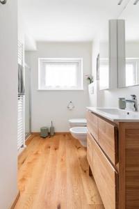 een witte badkamer met een toilet en een wastafel bij Appartamento a Val di Sopra, Cortina d'Ampezzo in Cortina dʼAmpezzo