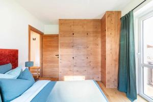 1 dormitorio con 1 cama y pared de madera en Appartamento a Val di Sopra, Cortina d'Ampezzo, en Cortina dʼAmpezzo