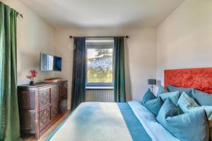 a bedroom with a blue bed and a window at Appartamento a Val di Sopra, Cortina d'Ampezzo in Cortina dʼAmpezzo