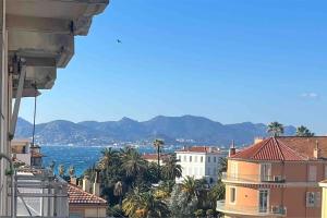 Blick auf eine Stadt mit Palmen und das Meer in der Unterkunft Studio lumineux à 2 mn à pied de la plage in Cannes