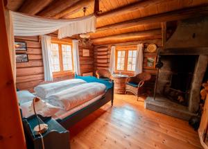 1 dormitorio con 1 cama y chimenea en una cabaña de madera en Røisheim Hotel & Skysstasjon, en Lom