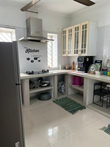 a kitchen with white cabinets and a refrigerator at Homestay GG Greenwood Gombak in Batu Caves