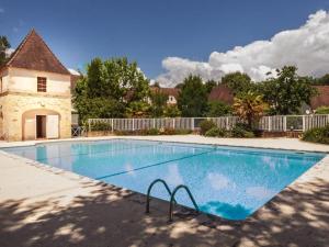 a large swimming pool in front of a house at Sur la Cave in Carsac-Aillac