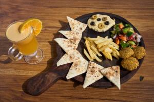 un plato de comida y un vaso de zumo de naranja en The Mad King's House & Cafe, en Manali
