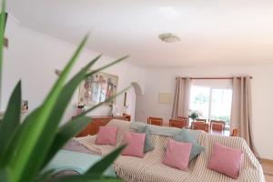 a living room with a couch with pink and blue pillows at Villa Carpe Diem (Seize the day) in Carvoeiro +47 photos