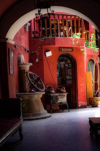 uma entrada para um edifício vermelho com uma arcada em Hostal Imperial Carlos V em Potosí