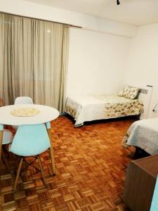 Habitación con cama, mesa y sillas. en Florida Garden 624 en Buenos Aires