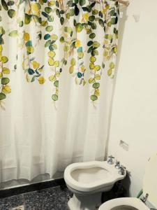y baño con aseo y cortina de ducha. en Florida Garden 624 en Buenos Aires