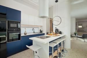 a kitchen with blue and white cabinets and a sink at Helius Villas in Aliki