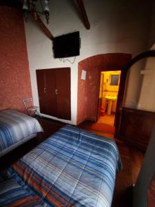 a bedroom with two beds and a flat screen tv at Hostal Imperial Carlos V in Potosí